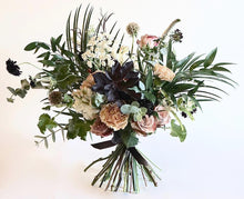 A bouquet bursting with seasonal flowers and foliage in dusky cappuccino, tan and white shades with pops of burgundy and lots of textures and greenery.