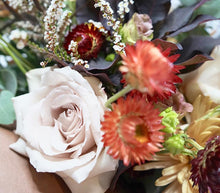 A bouquet full of seasonal flowers in warm autumnal colors.