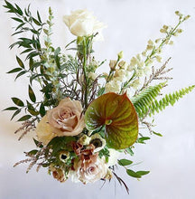 A flower jar bouquet full of seasonal flowers in a white and pastel pink color palette with bursts of greenery and lots of texture.