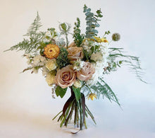 A bouquet full of summer flowers in a soft pale pink and creamy white with pops of yellow and lots of greenery and texture. 