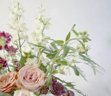 A flower jar bouquet full of seasonal summer flowers in shades of cappuccino, raspberry and scarlet with pops of white and pale pink and lots of greenery.