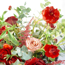 A bouquet bursting with seasonal flowers and foliage in shades of red and tan/cappuccino with lots of seasonal greenery and foliages and loads of texture.   This is not your average red rose Valentine's bouquet but perfect for those who love a little red!